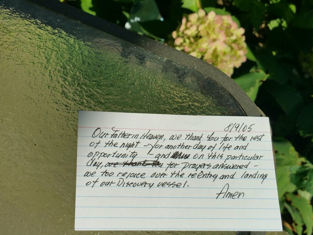 index card on glass table near hydrangea outside