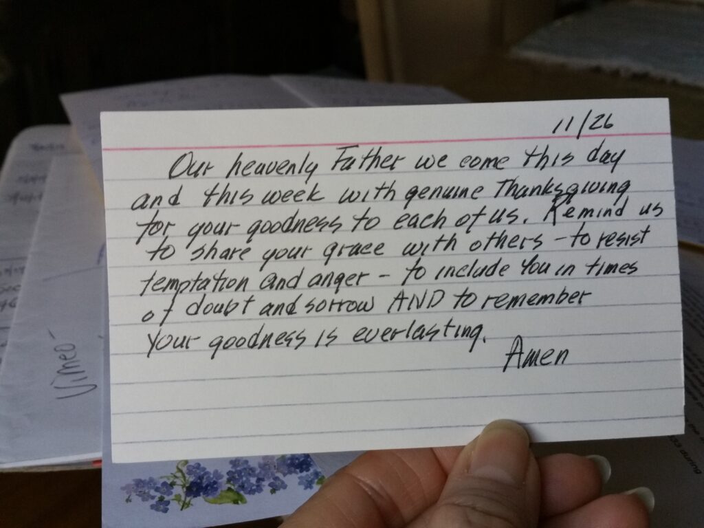 index card prayer on stack of notebooks